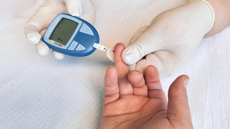 A healthcare worker checking a patient's blood glucose levels for effective chronic disease management.
